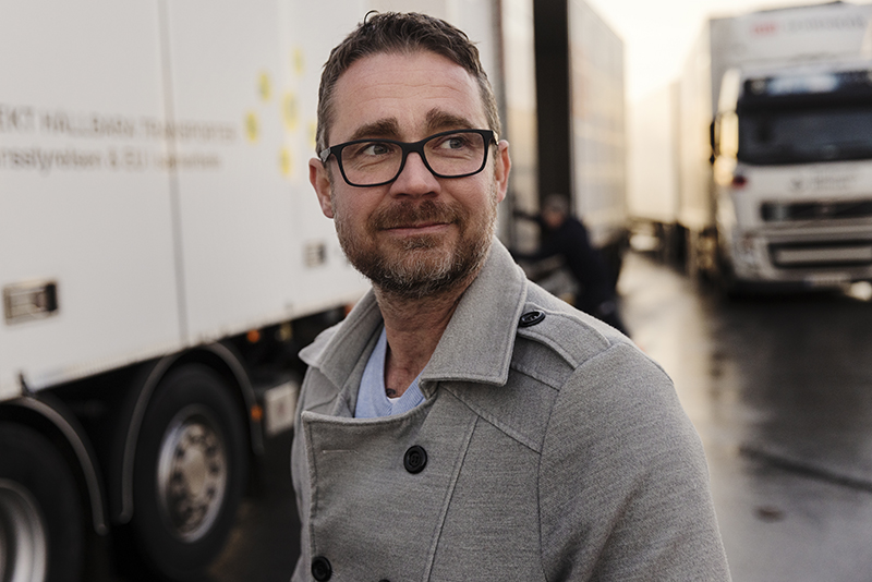 Man utanför lastbilar på en parkeringsplats