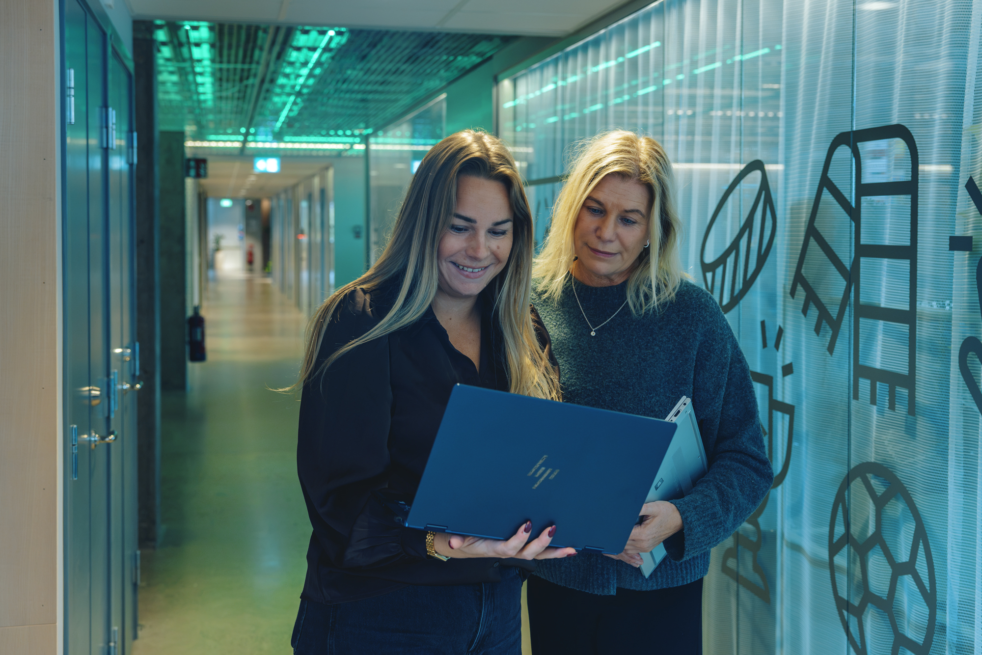 Två personer som jobbar på Svenska Spel i Visby tittar på en dator