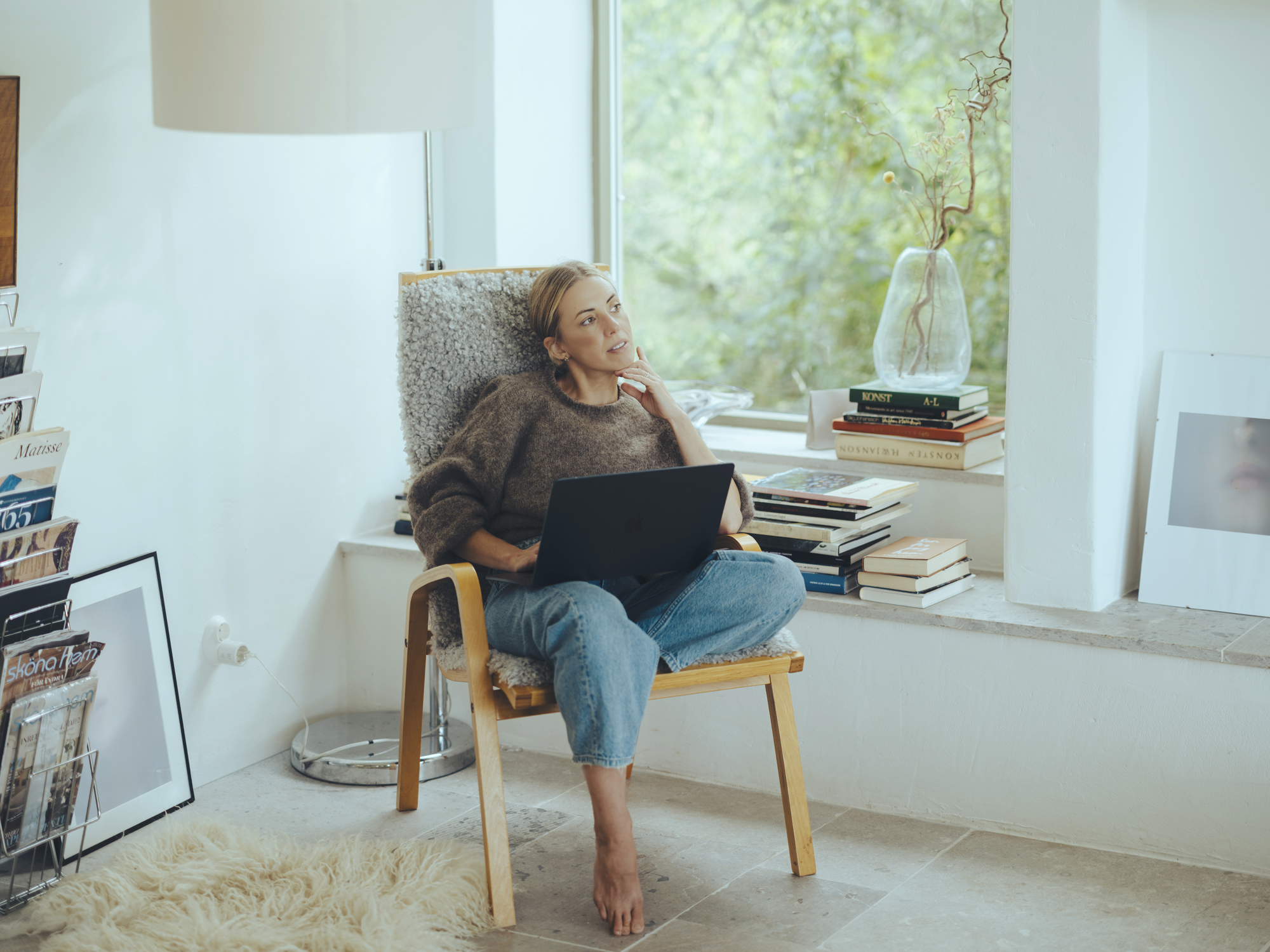 Julia Zernell fotograf på Gotland sitter i en stol i sitt gotlandshus